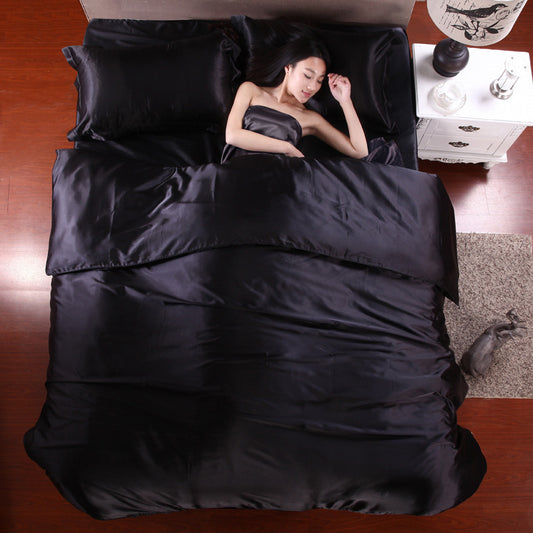 Elegant silk four-piece bedding set in black, featuring a luxurious and soft design for a stylish bedroom