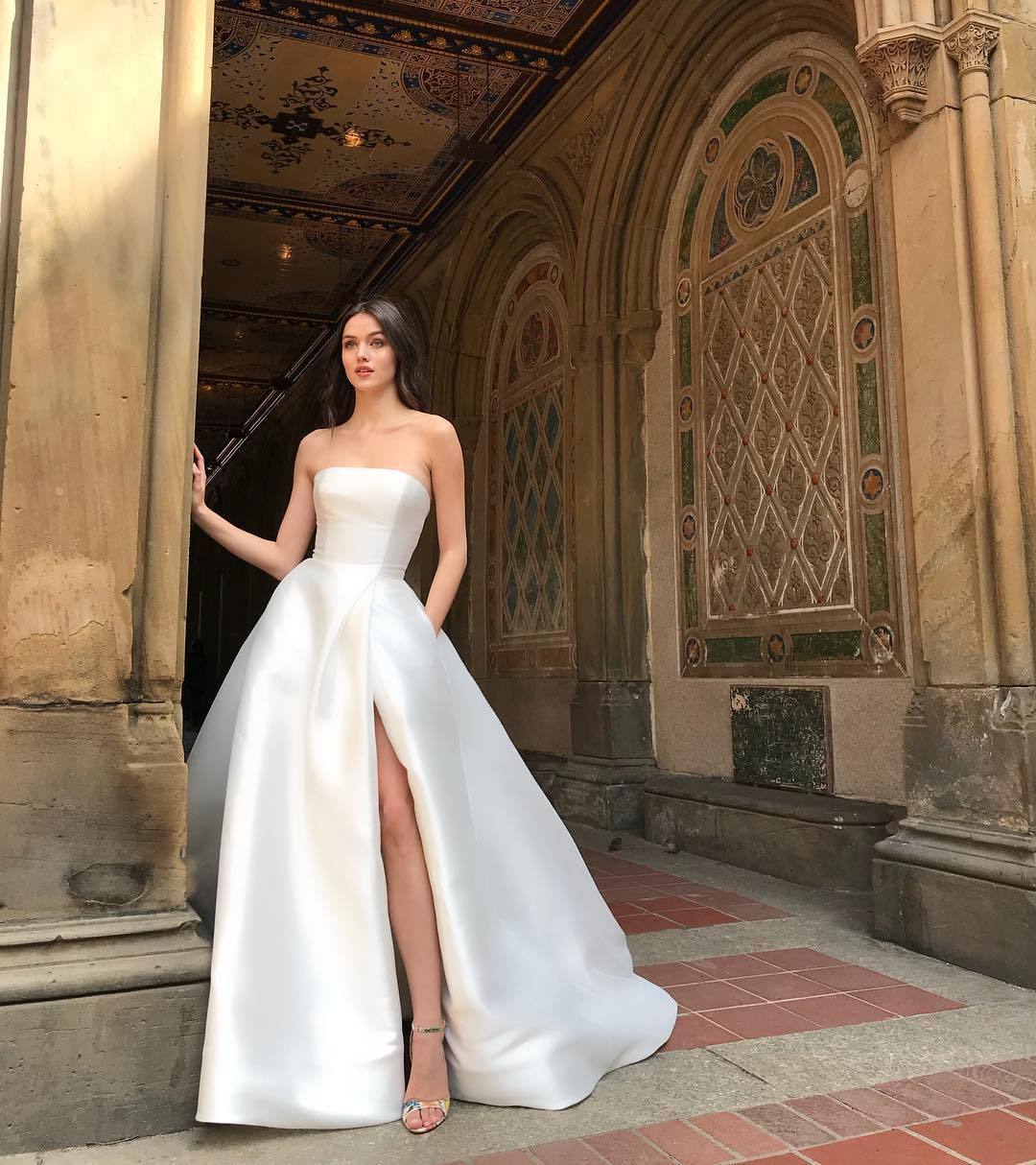 Elegant woman wearing a white bandeau high waist dress with a side slit for a fashionable look